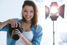 Beginner photographer holding a mirrorless camera while learning how to choose a camera in 2026