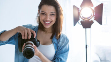 Beginner photographer holding a mirrorless camera while learning how to choose a camera in 2026