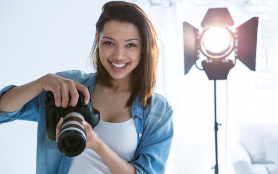 Beginner photographer holding a mirrorless camera while learning how to choose a camera in 2026